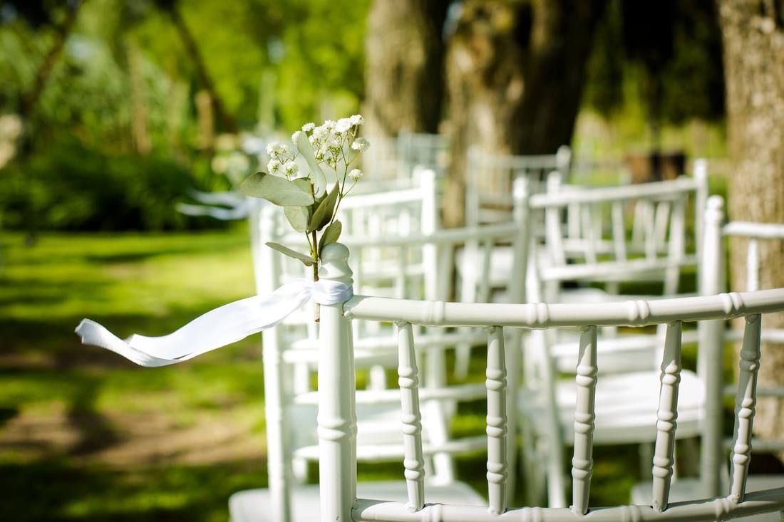 Sillas de la ceremonia con flores y cintas